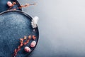 Easter decor. Close up of dishes with eggs, feathers and spring branches. Ceramic plates on grey background. Space Royalty Free Stock Photo