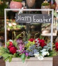 Easter decor. Festive flower arrangement of Protea, red roses, limonium sinuatum, eryngium, eucalyptus leaves and other plants in Royalty Free Stock Photo