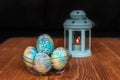 Easter decoration - blue, colorful painted eggs with gemstones and a blue candle lantern