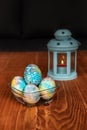 Easter decoration - blue, colorful painted eggs with gemstones and a blue candle lantern