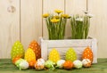 Easter decoration - candles,eggs and flowers in box on wooden background.