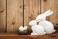 Easter decoration - ceramic easter rabbits on the wooden background.