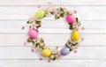 Easter decoration. Circle Easter frame of pink flowers apple tree, colored easter eggs and quail eggs