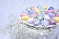 Easter decoration with colored eggs, and gypsophila close-up on a light background.