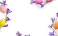 Easter decoration. Easter frame of flowers violet crocuses, colored easter eggs on white background with space for text. Top view Royalty Free Stock Photo