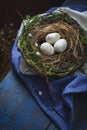 Easter decoration - a nest with wooden eggs - on old wooden t