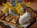 Easter decoration with rabbit and plates with tasty cake and fruit
