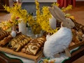 Easter decoration with rabbit, yellow flowers and plates with tasty cake and fruit