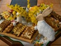 Easter decoration with rabbits and plates with tasty cake and fruit