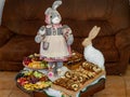 Easter decoration with rabbits and plates with tasty cake and fruit