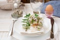 Easter decoration table setting, white plates, napkin, flowers in eggshell