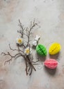 Easter decoration - tree branches, paper colored eggs, flowers, ceramic easter rabbit on a light background, top view. Handmade