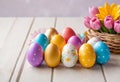 Easter decorations, colorfully painted and decorated Easter eggs and spring flowers on a wood background Royalty Free Stock Photo