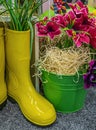 Easter decorations with yellow rubber boots, green metal bucket and flowers