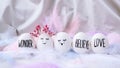Minimal easter concept. Easter eggs with painted smiley faces and bird feather on pastel background. Wedding couple eggs. Married