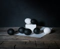 Easter. Easter night. Black and White eggs, feathers on a wooden table. Vintage. Dark background. Royalty Free Stock Photo