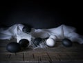 Easter. Easter night. Black and White eggs, feathers on a wooden table. Vintage. Dark background Royalty Free Stock Photo