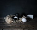 Easter. Easter night. Black and White eggs, feathers on a wooden table. Vintage. Dark background Royalty Free Stock Photo