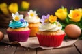 Easter pastries, homemade cupcakes decorated with colored eggs, spring flowers