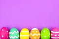 Easter egg bottom border over purple paper background Royalty Free Stock Photo