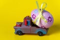 Easter egg on the car a yellow background Royalty Free Stock Photo