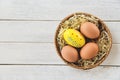 Easter egg and chicken eggs basket nest decoration on white wooden background top view Royalty Free Stock Photo