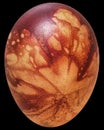 Easter Egg Decorated with Red Color and Leaves Imprints Isolated on Black Background