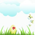 Easter egg in green grass under blue sky