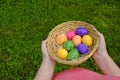 Easter Egg Hunt. Easter eggs set in a basket in children& x27;s hands on green grass background.Religious holiday tradition