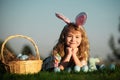 Easter egg hunt in garden. Child boy playing in field, hunting easter eggs, on sky background with copy space. Closeup Royalty Free Stock Photo