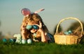 Easter egg hunt in garden. Children playing in field, hunting easter eggs. Cute bunny child boy with rabbit ears, on sky Royalty Free Stock Photo