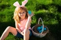 Easter egg hunt. Happy Easter. Kids in bunny ears with Easter egg in basket. Boy play in hunting eggs. Royalty Free Stock Photo