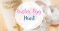 Easter egg hunt text over white christening candle on table Royalty Free Stock Photo