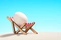 Easter egg in loungeron sandy beach Royalty Free Stock Photo