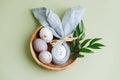 Easter egg in a napkin along with gilded eggs in a wooden bowl