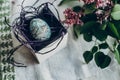 easter egg in nest with floral and chick ornaments on rustic background with lilac flowers. top view. space for text. happy Royalty Free Stock Photo