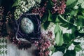 easter egg in nest with floral and chick ornaments on rustic background with lilac flowers. top view. space for text. happy Royalty Free Stock Photo