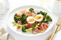 Easter egg salad with prosciutto and broccolini on white background. Easter salad with boiled egg Royalty Free Stock Photo