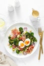 Easter egg salad with prosciutto and broccolini on white background, top view. Easter salad with boiled egg Royalty Free Stock Photo