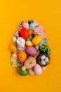 Easter egg shape made of colorful spring flowers and eggs on yellow background.  Easter celebration concept. Top view. Flat lay Royalty Free Stock Photo