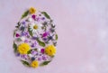 Easter egg shape made of colorful spring flowers and green leaves. Minimal holiday concept. Flat lay pattern. Royalty Free Stock Photo