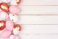 Easter egg side border. Rose gold, pink and white on white wood. Royalty Free Stock Photo