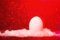 Easter egg in snow with red light bokeh Royalty Free Stock Photo