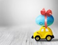 Easter egg and toy car on light grey background, happy easter day concept Royalty Free Stock Photo