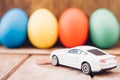 Easter egg and toy car on wooden background Royalty Free Stock Photo