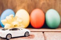 Easter egg and toy car on wooden background Royalty Free Stock Photo