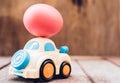 Easter egg and toy car on wooden background Royalty Free Stock Photo