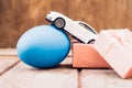 Easter egg and toy car on wooden background Royalty Free Stock Photo