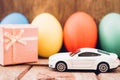 Easter egg and toy car on wooden background Royalty Free Stock Photo