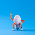 Easter egg toy in the shape of a light bulb on a blue Royalty Free Stock Photo
